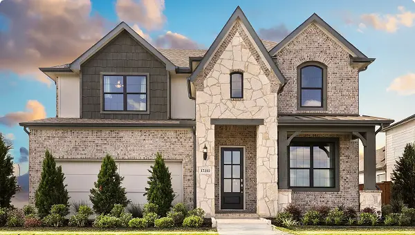 Two-story Grand Magnolia home with brick and stone exterior in Waller ISD, landscaped yard.