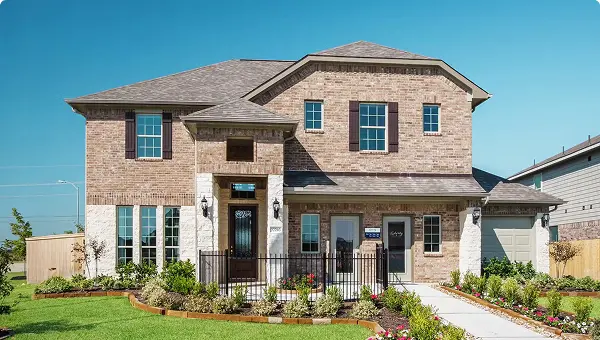Two-story brick house in Grand Magnolia, Magnolia TX, with landscaped yard and attached garage.