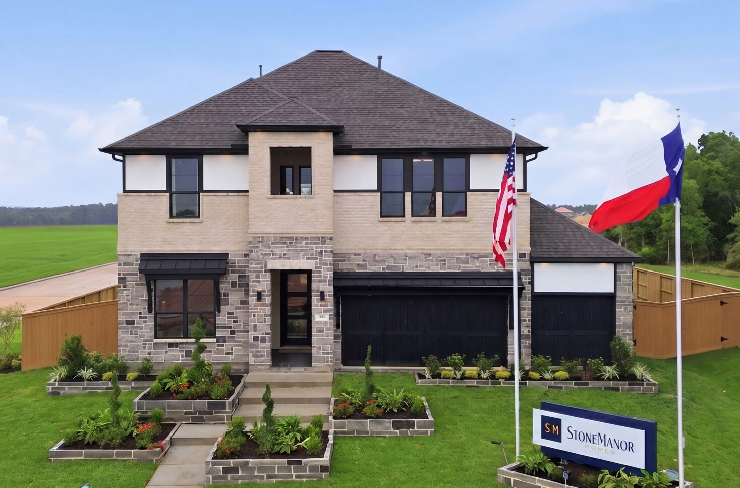 Two-story modern house with a lawn, three flags, and a Stone Manor sign out front.